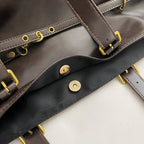 Close-up of a leather bag showing its magnetic snap closure and gold hardware