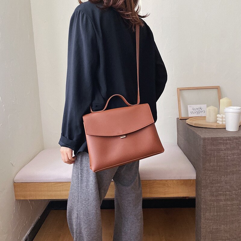 Woman using a leather shoulder bag