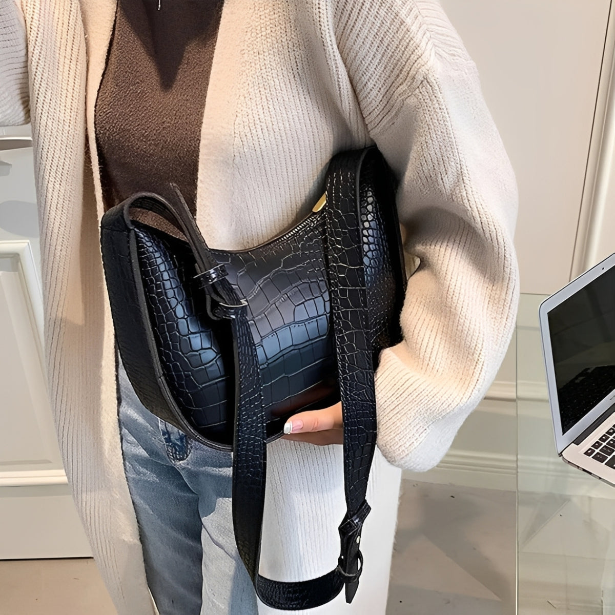 Woman holding a black crocodile-patterned leather handbag 