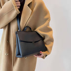 Woman wearing a black leather shoulder bag